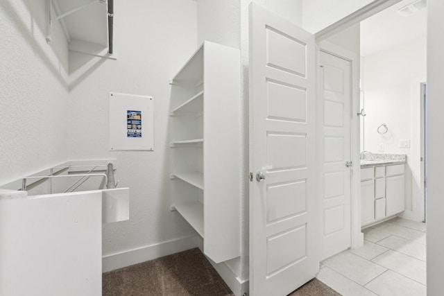 walk in closet with light tile patterned floors