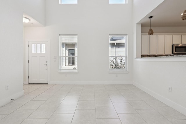 foyer entrance with a high ceiling and light tile patterned floors