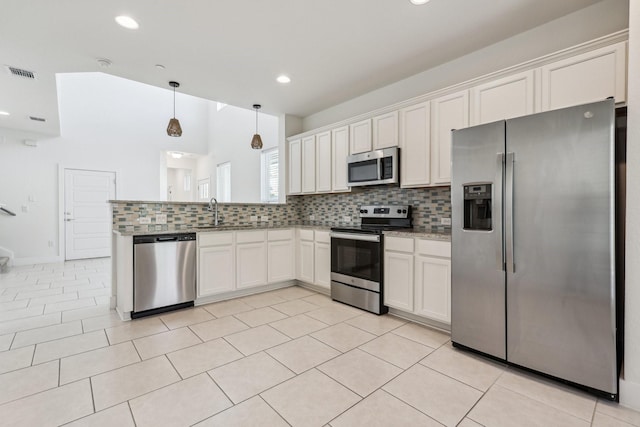 kitchen with white cabinetry, hanging light fixtures, light tile patterned floors, stainless steel appliances, and decorative backsplash