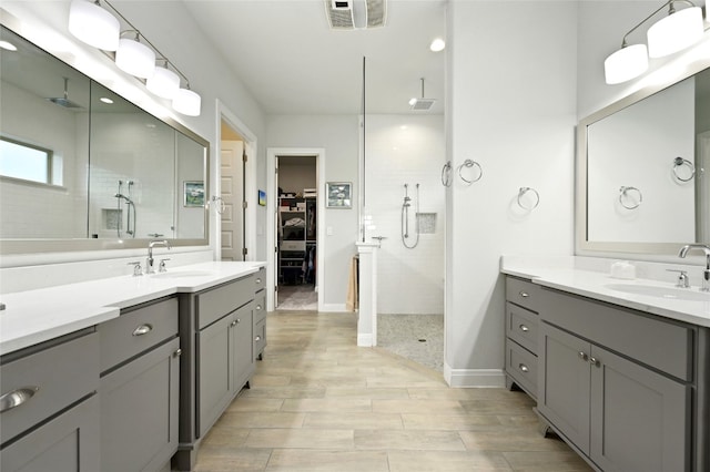 full bath with baseboards, wood finish floors, a sink, and a shower stall