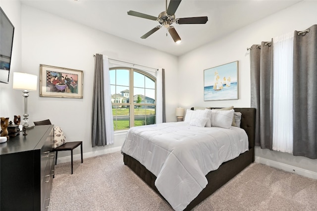 bedroom featuring light carpet, ceiling fan, and baseboards