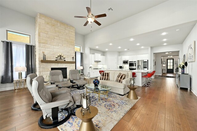 living room with ceiling fan, a healthy amount of sunlight, a fireplace, and wood-type flooring