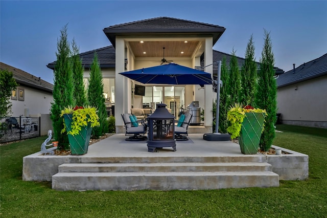 back of house featuring a lawn, ceiling fan, and a patio area