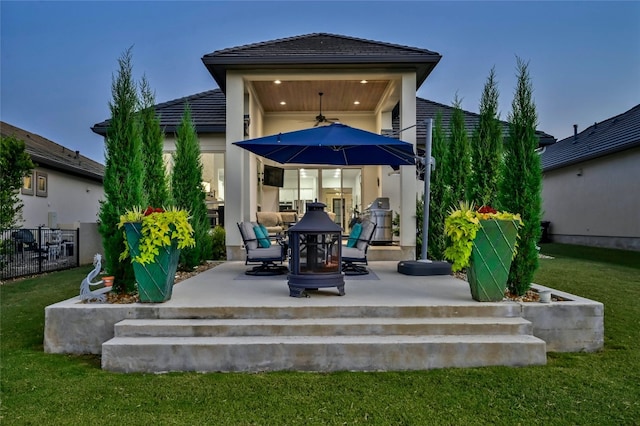 back of property featuring a yard, a patio, stucco siding, ceiling fan, and fence