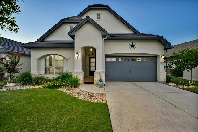 view of front of house with a garage, stone siding, driveway, and stucco siding