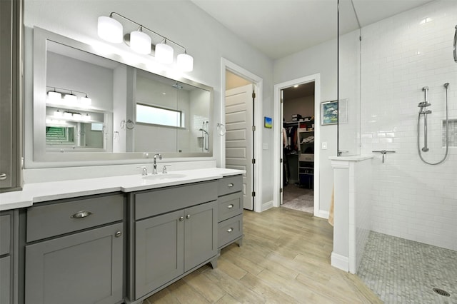 bathroom with vanity and a tile shower