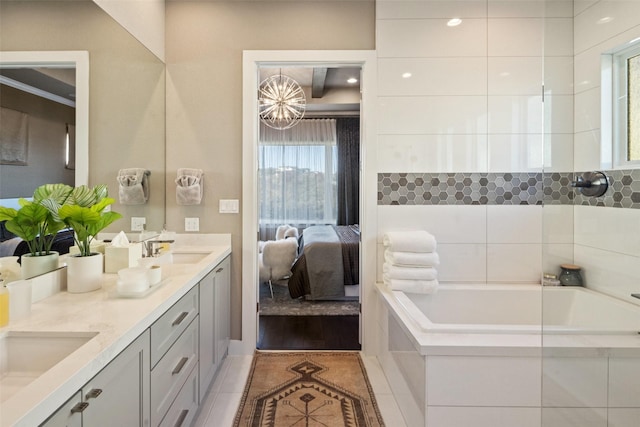 bathroom with tile patterned floors, a bathing tub, and vanity