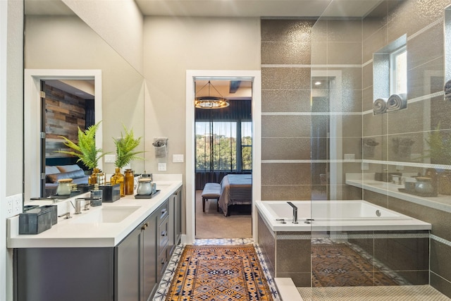 bathroom featuring a relaxing tiled tub, tile patterned floors, and vanity