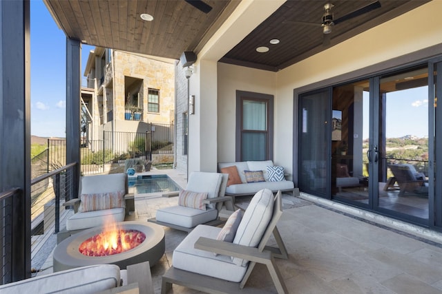 view of patio with an outdoor living space with a fire pit and french doors