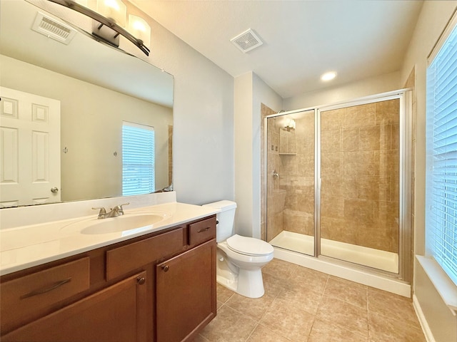 bathroom featuring vanity, walk in shower, tile patterned floors, and toilet