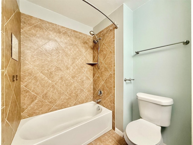 bathroom featuring tile patterned flooring, tiled shower / bath combo, and toilet