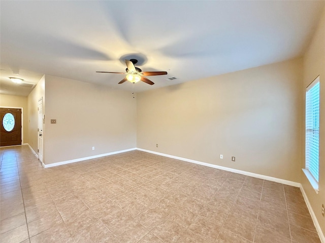 unfurnished room with ceiling fan and a wealth of natural light