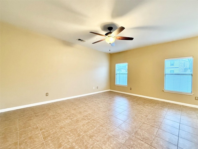 spare room with ceiling fan and light tile patterned floors