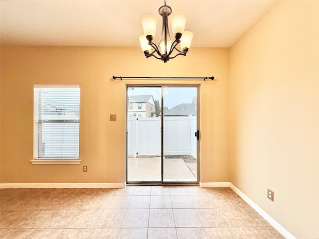 empty room featuring an inviting chandelier and light tile patterned floors