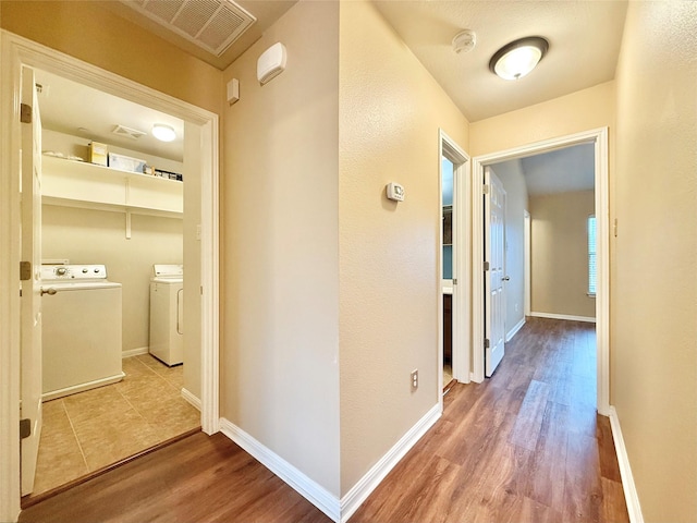 hall featuring hardwood / wood-style flooring and washing machine and clothes dryer