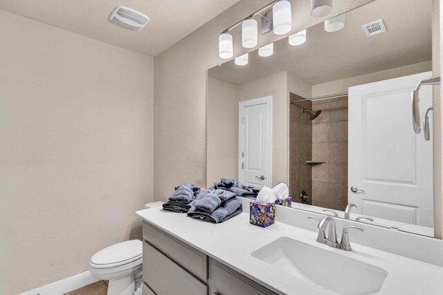 bathroom featuring a shower, visible vents, vanity, and toilet