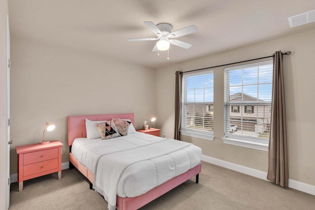 bedroom with light carpet, a ceiling fan, visible vents, and baseboards