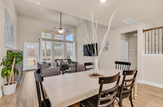 dining area with ceiling fan, light wood finished floors, visible vents, and baseboards