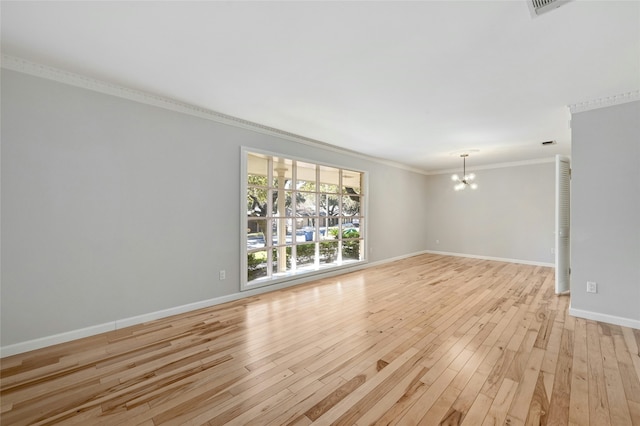 unfurnished room with an inviting chandelier, crown molding, and light hardwood / wood-style flooring