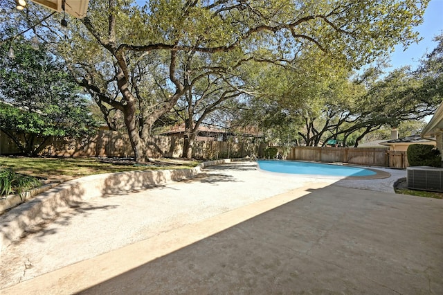 view of swimming pool with cooling unit and a patio