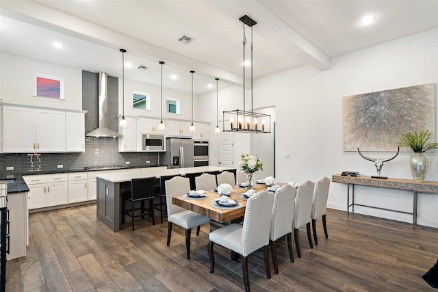 dining room with dark hardwood / wood-style flooring, a chandelier, and beamed ceiling