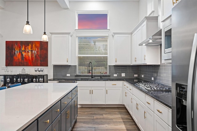 kitchen with sink, white cabinetry, tasteful backsplash, hanging light fixtures, and appliances with stainless steel finishes