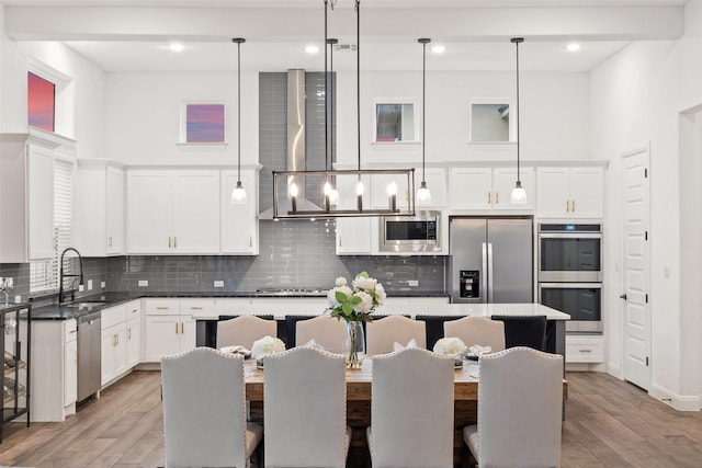 kitchen featuring pendant lighting, appliances with stainless steel finishes, a center island, and sink