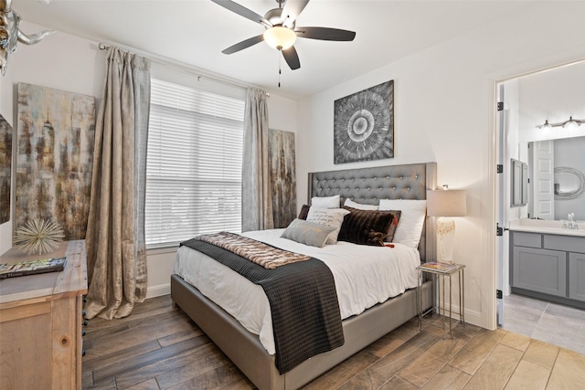 bedroom featuring ceiling fan, ensuite bathroom, and sink