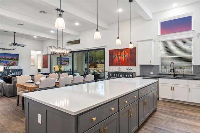 kitchen featuring white cabinetry, beam ceiling, decorative light fixtures, and gray cabinetry