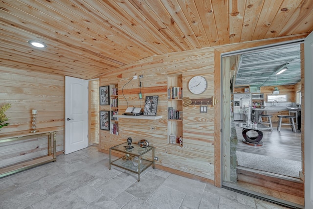 interior space featuring wooden ceiling, lofted ceiling, and wood walls