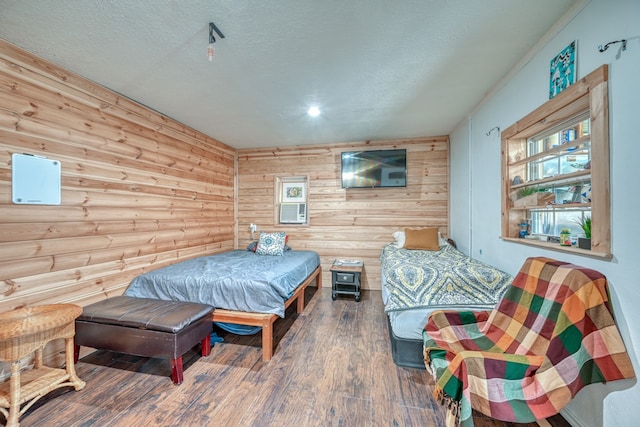 bedroom with hardwood / wood-style flooring, a textured ceiling, and wood walls