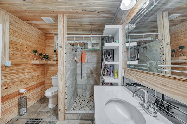 bathroom with wooden ceiling, toilet, vanity, and wood walls