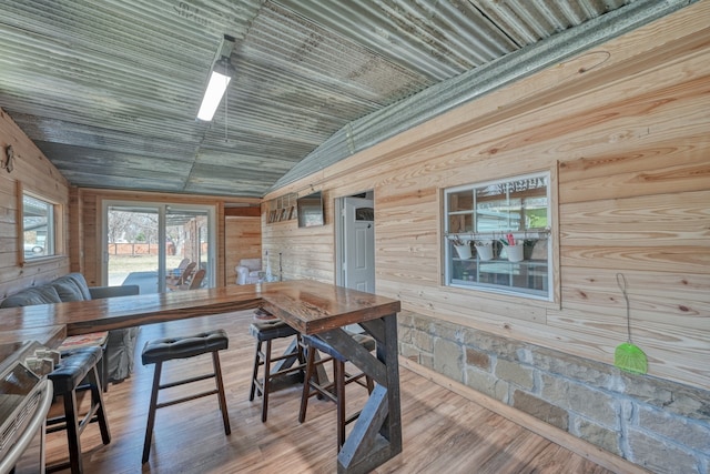 interior space featuring lofted ceiling, hardwood / wood-style flooring, wooden walls, and wooden ceiling