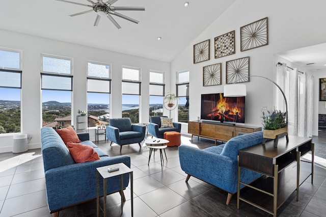 tiled living room featuring a fireplace, high vaulted ceiling, and a healthy amount of sunlight