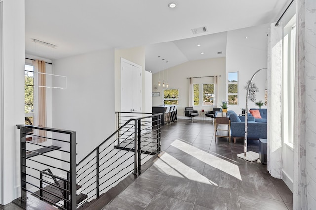 staircase featuring vaulted ceiling and a healthy amount of sunlight