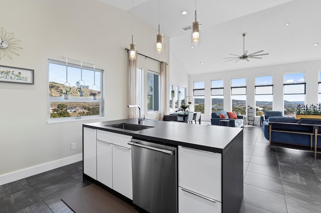 kitchen with sink, white cabinetry, stainless steel dishwasher, plenty of natural light, and an island with sink