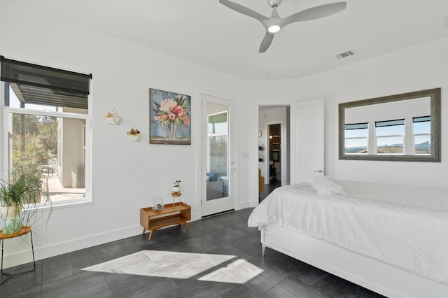 bedroom with multiple windows, dark tile patterned floors, and ceiling fan