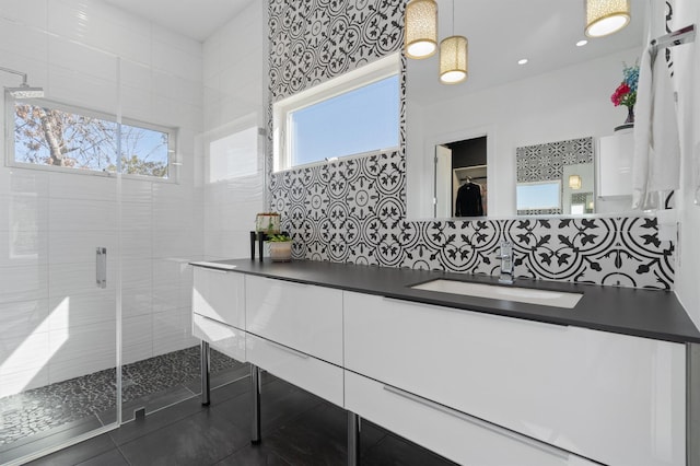 bathroom with walk in shower, vanity, and tile patterned flooring