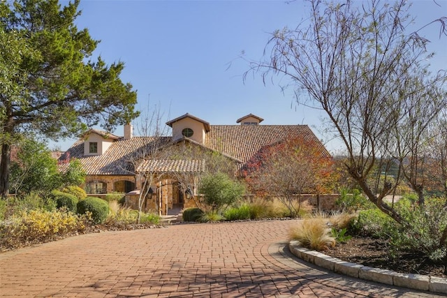 mediterranean / spanish house with a tile roof and stucco siding