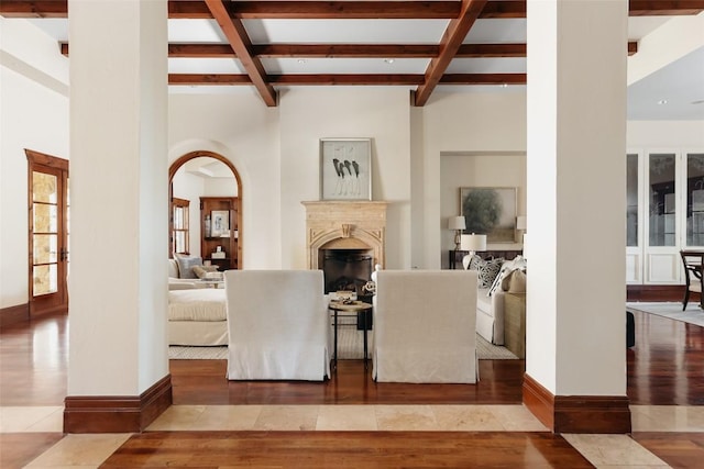 dining area with a glass covered fireplace, coffered ceiling, wood finished floors, and beam ceiling