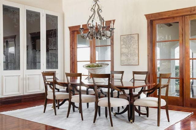 dining space featuring wood finished floors and a notable chandelier