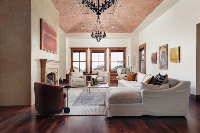 living area with a fireplace, a notable chandelier, vaulted ceiling, wood finished floors, and brick ceiling