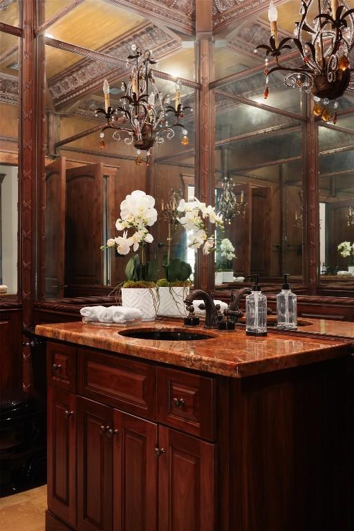 bar with hanging light fixtures, a chandelier, and a sink