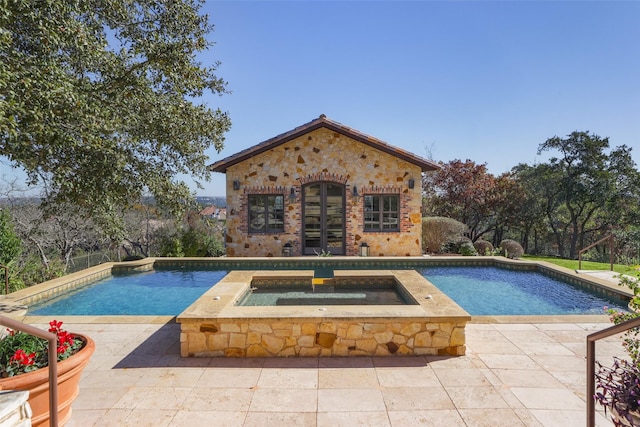 outdoor pool featuring an outbuilding, an in ground hot tub, a patio, and a storage structure