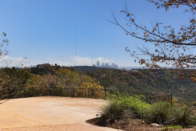 view of patio / terrace featuring a view of city and fence