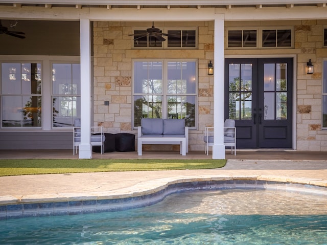 entrance to property featuring a pool with hot tub, a patio area, ceiling fan, and french doors