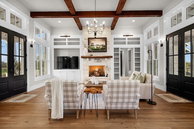 living room featuring built in features, beamed ceiling, wood-type flooring, coffered ceiling, and french doors