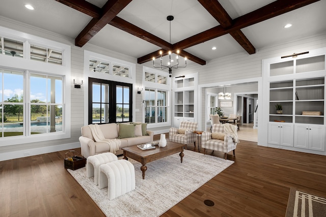 living room featuring french doors, beam ceiling, an inviting chandelier, and built in shelves