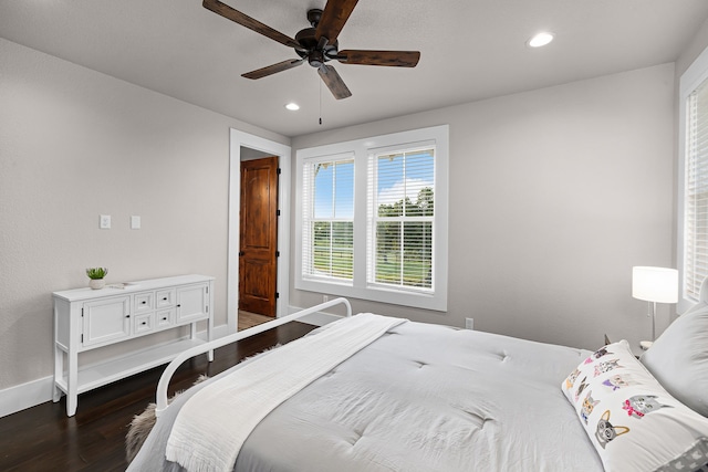 bedroom with dark hardwood / wood-style flooring and ceiling fan