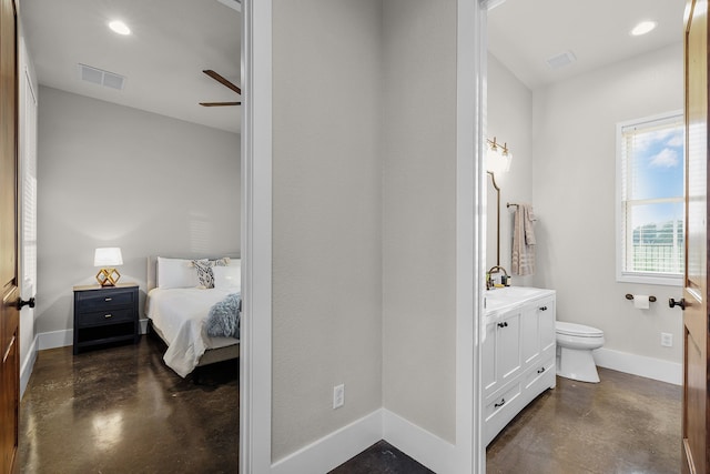 bedroom with ceiling fan, ensuite bathroom, and sink